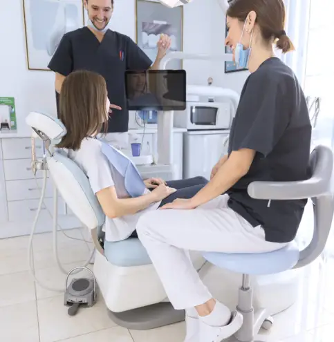 Gabinete dental con paciente y dentistas hablando